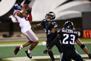 New York Giants' Sterling Shepard (87) catches a touchdown pass against Philadelphia Eagles' Darius Slay (24) and Rodney McLeod (23) during the second half of an NFL football game, Thursday, Oct. 22, 2020, in Philadelphia. (AP Photo/Derik Hamilton)