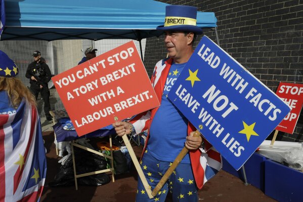 Anti Brexit campaigner Steve Bray holds banners outside the entrance to the Labour Party Conference at the Brighton Centre in Brighton, England, Monday, Sept. 23, 2019. (AP Photo/Kirsty Wigglesworth)