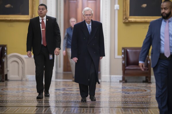 Senate Minority Leader Mitch McConnell, R-Ky., center, arrives as the Senate prepares to take a procedural vote on an emergency spending package that would provide military aid to Ukraine and Israel, replenish U.S. weapons systems and provide food, water and other humanitarian aid to civilians in Gaza, at the Capitol in Washington, Sunday, Feb. 11, 2024. (AP Photo/J. Scott Applewhite)
