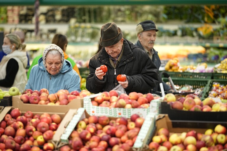 FILE - People buy fruit at a market in Moscow, Russia, on Nov. 3, 2023. The shelves at Moscow supermarkets are full of fruit, vegetables, cheese and meat, but many shoppers look at the selection with dismay as inflation drives up their price. (AP Photo)
