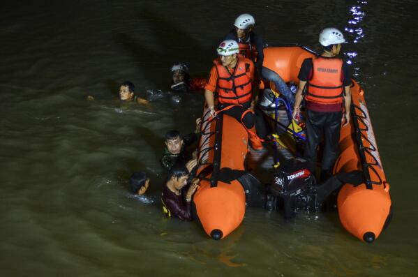 Rescuers search for victims of drowning in a river in Ciamis, West Java, Indonesia, Friday, Oct. 15, 2021. A number of students drowned during a school outing for a river cleanup on Friday evening in Indonesia's West Java Province. (AP Photo/Yopi Andrias)