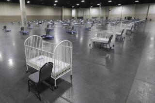 FILE - Cots and cribs are arranged at the Mountain America Expo Center in Sandy, Utah, on April 6, 2020, as an alternate care site or for hospital overflow amid the COVID-19 pandemic. According to a National Center for Health Statistics report released on Wednesday, Feb. 23, 2022, maternal mortality rates for U.S. women climbed higher in the pandemic's first year, continuing a trend that disproportionately affects Black mothers. (AP Photo/Rick Bowmer, File)
