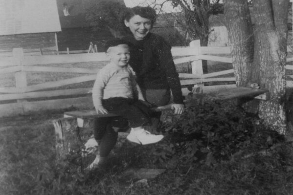 In this image provided by the McConnell Center at the University of Louisville, Mitch McConnell sits with his mother Julia "Dean" McConnell on a bench in this image from the mid 1940's in Five Points, Ala.. As the coronavirus pandemic unfolds, Senate Majority Leader Mitch McConnell flashes back to an earlier crisis that gripped the nation, and his own life, when he was a boy. He was struck with polio. (McConnell Center at the University of Louisville via AP)