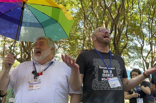 The Rev. David Meredith, left, and the Rev. Austin Adkinson sing during a gathering of those in the LGBTQ community and their allies outside the Charlotte Convention Center, in Charlotte, N.C., Thursday, May 2, 2024. They were celebrating after the General Conference of the United Methodist Church voted to remove the denomination's 52-year-old social teaching that deemed homosexuality "incompatible with Christian teaching." (Ǻ Photo/Peter Smith)