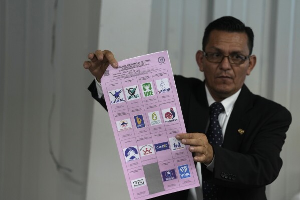An electoral authority holds up an invalid ballot during a meeting with political party lawyers, in Guatemala City, Tuesday, July 4, 2023. The Constitutional Court ordered the investigation of alleged irregularities claimed by political parties that lost in the June 25th general elections. (AP Photo/Moises Castillo)
