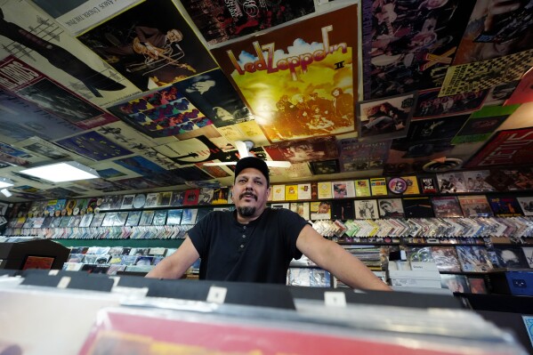 Tim Stamper, owner at Tracks In Wax record shop, pauses in his shop, Thursday, April 18, 2024, in Phoenix. Special LP releases, live performances and at least one giant block party are scheduled around the U.S. Saturday as hundreds of shops celebrate Record Store Day amid a surge of interest in vinyl and the day after the release of Taylor Swift's latest album. (AP Photo/Ross D. Franklin)
