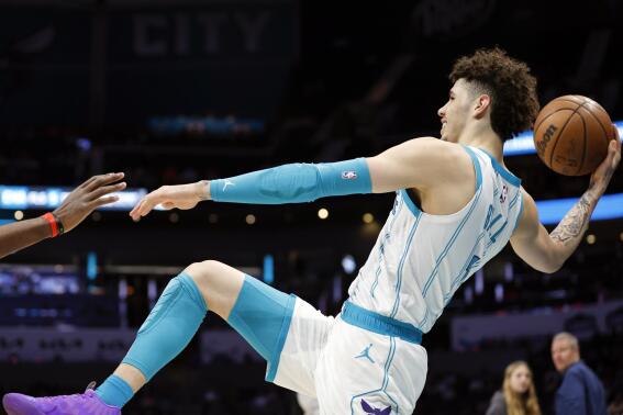 Charlotte Hornets guard LaMelo Ball passes the ball as he tries to stay inbound during the first half of an NBA basketball game against the Atlanta Hawks in Charlotte, N.C., Monday, Feb. 13, 2023. (AP Photo/Nell Redmond)