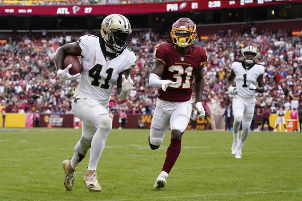 New Orleans Saints running back Alvin Kamara, left, rushes past Washington Football Team free safety Kamren Curl for a touchdown in the second half of an NFL football game, Sunday, Oct. 10, 2021, in Landover, Md. (AP Photo/Alex Brandon)