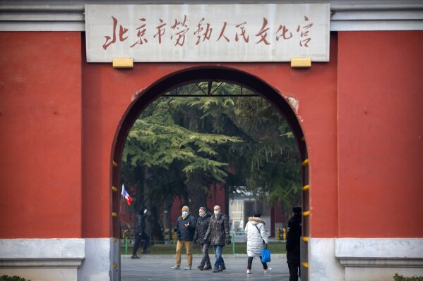 In this Jan. 27, 2020, photo, members of a group of foreign tourists wearing face masks to protect against the coronavirus walk through a public park near the Forbidden City in Beijing. The U.S. has issued a new advisory Tuesday, Sept. 15, 2020, warning against travel to mainland China and Hong Kong, citing the risk of "arbitrary detention" and "arbitrary enforcement of local laws." (AP Photo/Mark Schiefelbein)