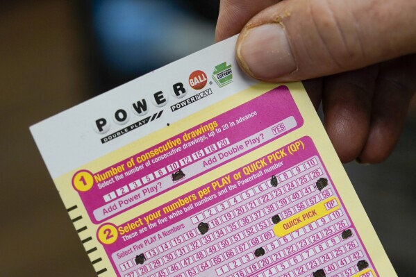 FILE - A person shows their scan card for their personal selection numbers for a ticket for a Powerball drawing on Nov. 7, 2022, at a convenience store in Renfrew, Pa. A winning ticket has been sold in California for Wednesday's drawing on July 19, 2023, for the Powerball jackpot worth $1 billion. (AP Photo/Keith Srakocic, File)