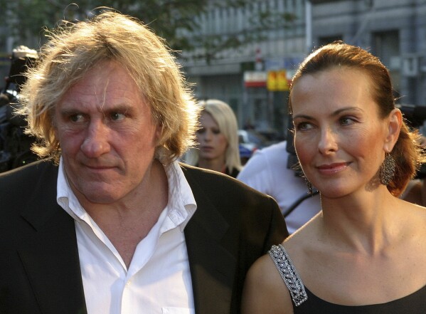 French actor Gerard Depardieu, left, and French actress Carol Bouquet arrive at the red carpet for the closing ceremony of the 10th Sarajevo Film Festival at the National Theater in Sarajevo, on Aug 28, 2004. (AP Photo/Hidajet Delic, File)