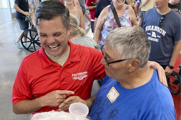 Iowa Republican candidate for Congress Zach Nunn, left, laughs while talking with Arvin Foell of Kelley, Iowa, during an appearance at the Iowa State Fair, in Des Moines, Iowa, August 12, 2022. Nunn is among more than a dozen strict abortion opponents running in competitive House, Senate and governor races working to soften his profile in light of increased enthusiasm among Democratic voters since the June U.S. Supreme Court decision reversing a federal right to abortion. (AP Photo/Thomas Beaumont)