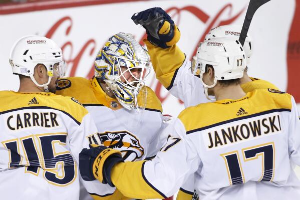 Nashville Predators goalie Kevin Lankinen celebrates with Alexandre Carrier, left, and Mark Jankowski after the Predators defeated the Calgary Flames in an NHL hockey game in Calgary, Alberta, Thursday, Nov. 3, 2022. (Larry MacDougal/The Canadian Press via AP)