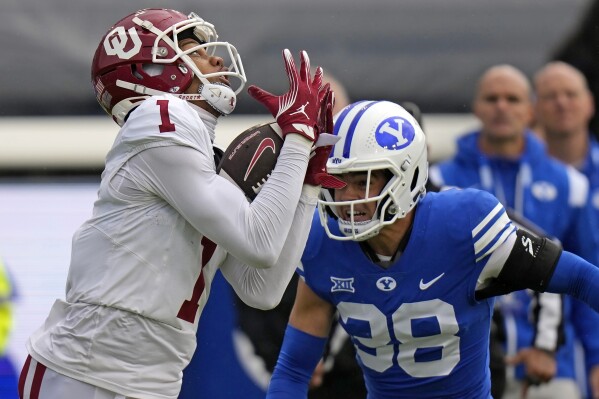 Oklahoma wide receiver Jayden Gibson (1) catches a pass over BYU safety Crew Wakley (38) during the first half of an NCAA college football game Saturday, Nov. 18, 2023, in Provo, Utah. (AP Photo/Rick Bowmer)