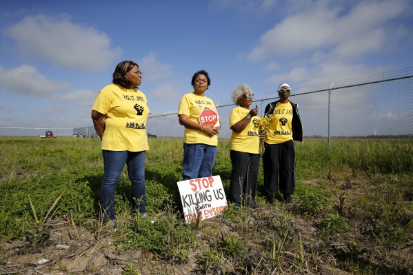 FILE - Myrtle Felton, from left, Sharon Lavigne, Gail LeBoeuf and Rita Cooper conduct a live stream video on property owned by Formosa Plastics on March 11, 2020, in St. James Parish, La. The Environmental Protection Agency spent more than a year investigating whether Louisiana's oversight of industrial air emissions discriminated against Black residents. The EPA’s investigation ended, however, before it secured commitments from the state to strengthen its oversight. (AP Photo/Gerald Herbert, File)