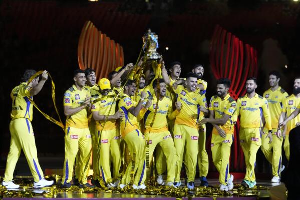 Players of Chennai Super Kings celebrate with the winners trophy after their win in the Indian Premier League final cricket match against Gujarat Titans in Ahmedabad, India, Tuesday, May 30, 2023. (AP Photo/Ajit Solanki)