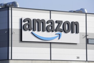 FILE - An Amazon company logo marks the facade of a building in Schoenefeld near Berlin, March 18, 2022. The Federal Trade Commission and 17 state attorney generals filed an antitrust lawsuit against Amazon on Tuesday, Sept. 26, 2023, alleging the e-commerce behemoth uses its position in the marketplace to inflate prices on other platforms, overcharge sellers and stifle competition. (AP Photo/Michael Sohn, File)