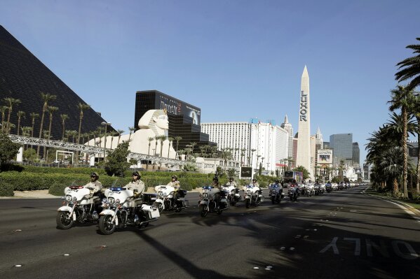 
              The funeral procession for Las Vegas police officer Charleston Hartfield drives down the Las Vegas Strip Friday, Oct. 20, 2017, in Las Vegas.  The off-duty police officer was one of 58 people killed when a gunman fired from the hotel into a crowded outdoor concert on Oct. 1. (AP Photo/Isaac Brekken)
            