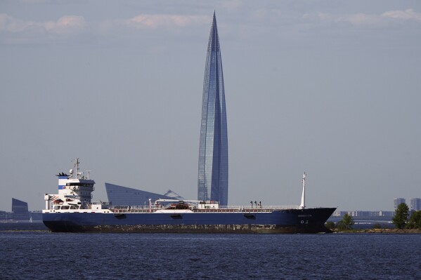 FILE - 'Nimbus SPB', an oil products tanker, floats in the Finnish Gulf past the Lakhta Center skyscraper, the headquarters of Russian gas monopoly Gazprom in St. Petersburg, Russia, on June 11, 2023. Oil prices have risen, meaning drivers are paying more for gasoline and truckers and farmers more for diesel. The increase also is complicating the global fight against inflation and feeding Russia's war chest to boot. (AP Photo/Dmitri Lovetsky, File)