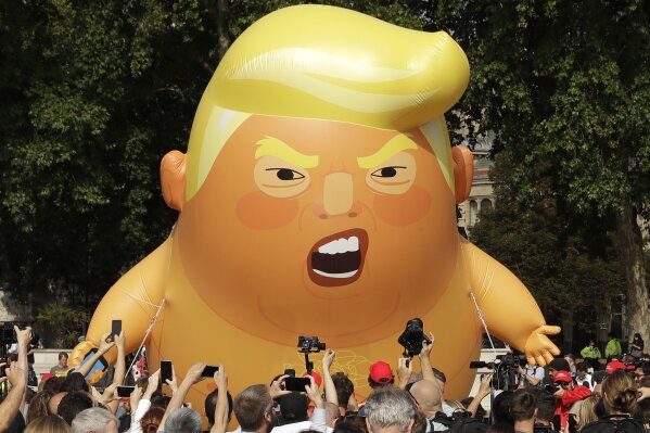 
              FILE - In this Friday, July 13, 2018 file photo a six-meter high cartoon baby blimp of U.S. President Donald Trump is flown as a protest against his visit, in Parliament Square in London, England. The leader of Britain’s opposition Labour Party says he has declined an invitation to the state dinner during U.S. President Donald Trump’s upcoming visit. Jeremy Corbyn said Friday, April 26, 2019 he would be happy to meet with Trump but thinks “maintaining an important relationship with the United States does not require the pomp and ceremony of a state visit.”  (AP Photo/Matt Dunham, File)
            