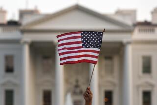 FILE - A flag is waved during an immigration rally outside the White House, in Washington, Sept. 4, 2017. The Biden administration is reinstating a task force disbanded under Donald Trump that is aimed at helping immigrants and refugees integrate into the U.S. The task force on New Americans will be run by the Domestic Policy Council and the work will focus on workforce training, education and financial access and language learning and health and well-being. (AP Photo/Carolyn Kaster, File)