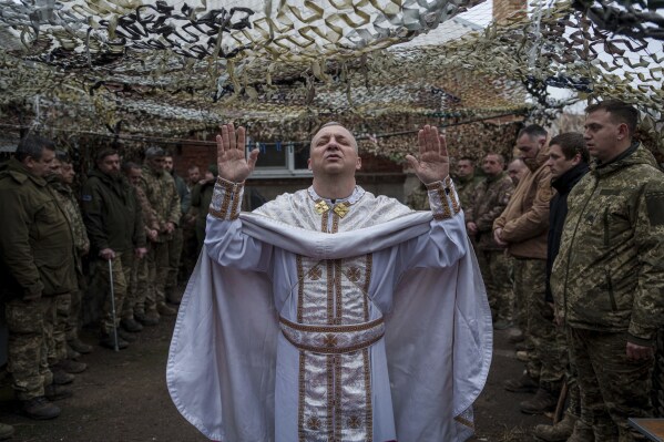 Military chaplain Yurii of the 24th Mechanized Brigade holds a church service for an infantry unit during Christmas near the frontline town of Chasiv Yar, Donetsk region, Ukraine, Wednesday Dec. 25, 2024. (AP Photo/Evgeniy Maloletka)