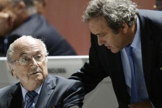 FILE - FIFA President Sepp Blatter, left, and UEFA President Michel Platini are engaged in conversation during the 65th FIFA Congress held at the Hallenstadion in Zurich, Switzerland, on Friday, May 29, 2015. Swiss prosecutors have charged former FIFA officials Sepp Blatter and Michel Platini with fraud and other offenses. (Walter Bieri/Keystone via AP)