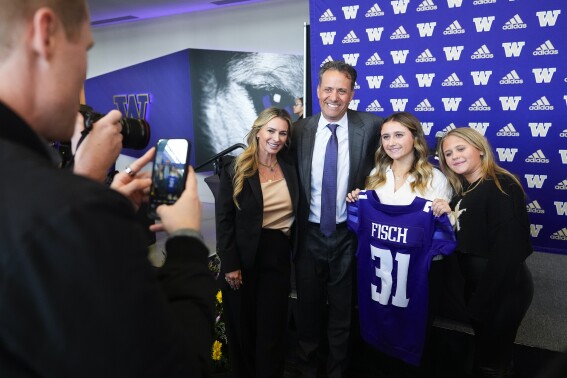 New Washington head coach Jedd Fisch poses with his wife Amber, left, and daughters Ashlee, third from left, and Kendall, right, after an NCAA college football press conference Tuesday, Jan. 16, 2024, in Seattle. (AP Photo/Lindsey Wasson)