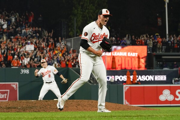 Baltimore Orioles starting pitcher Tyler Wells, right, reacts after recording the final out in a 2-0 victory over the Boston Red Sox in a baseball game to win the AL East championship, Thursday, Sept. 28, 2023, in Baltimore. (AP Photo/Julio Cortez)