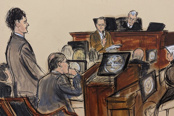 In this courtroom sketch, Sam Bankman-Fried, far left, stands as the jury foreperson, standing far right, reads the verdict with Judge Lewis Kaplan presiding on the bench in Manhattan federal court, Thursday, Nov. 2, 2023, in New York. A New York jury has convicted FTX founder Sam Bankman-Fried of fraud charges. The 31-year-old California man was convicted Thursday in Manhattan federal court by jurors who rejected his testimony that he didn't defraud customers.(Elizabeth Williams via AP)