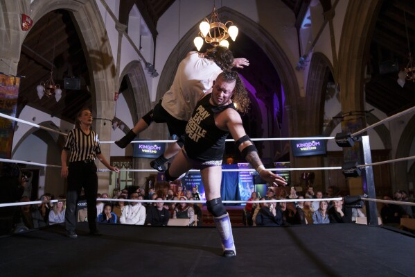 Gareth "Angel" Thompson azota a Young Johnty durante un espectáculo de Kingdom Wrestling en la iglesia de San Pedro en Shipley, el sábado 29 de marzo de 2025. (Foto AP/Jon Super)
