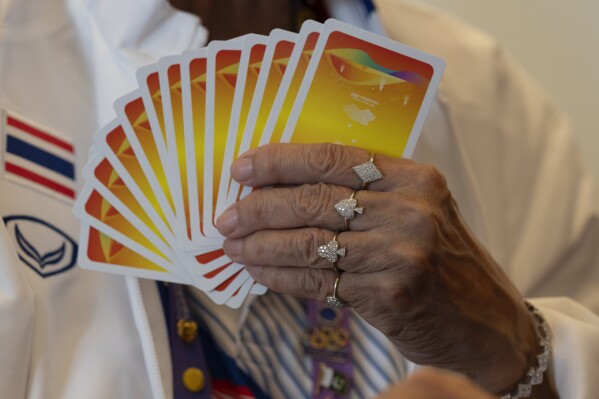 Manthanee Yaisawang from Thailand wears jewelry with the Diamond, Spade, Club and Heart symbol of playing cards as she takes part in the Bridge Women's Team Round Robin event against India for the 19th Asian Games in Hangzhou, China, Wednesday, Sept. 27, 2023. The 500-year-old card game of bridge is another type of "esport" at the Asian Games. With an apology to the demographic, here the "e" stands for elderly, not electronic, as in the youth-driven, video-game competition that's soaring in popularity, generating billions in revenue, and producing superstars like the South Korean gamer known as Faker. (AP Photo/Ng Han Guan)