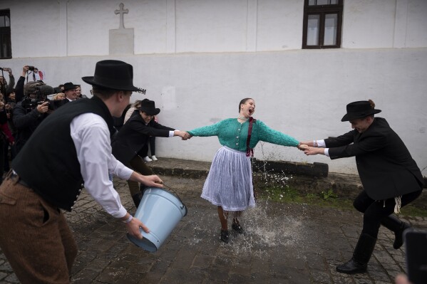 Hungarian men wearing folk costumes pour water onto women during a traditional a Easter Monday celebration in Holloko, Hungary, April 10, 2023. (AP Photo/Denes Erdos)