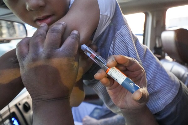 Renee Barbian gives an insulin shot to her immunocompromised son Ezekiel Barbian in the parking lot of a grocery store, Monday, Feb. 24, 2025, in Hobbs, N.M. (AP Photo/Julio Cortez)