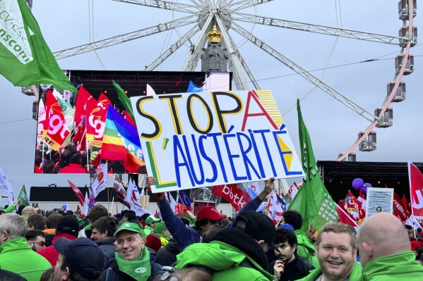 A protestor holds a sign which reads 'stop austerity' during a demonstration against austerity measures in Brussels, Tuesday, Dec. 12, 2023. Thousands of protesters gathered in Brussels on Tuesday to protest what they perceive as new austerity measures as the 27 European Union countries discuss ways to overhaul rules on government spending. (AP Photo/Sylvain Plazy)