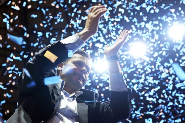 Luis Montenegro, leader of the center-right Democratic Alliance coalition, cheers as confetti rains down on him at the end of a campaign closing rally in Lisbon, Portugal, Friday, March 8, 2024. (AP Photo/Armando Franca)