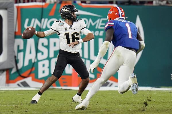 Central Florida quarterback Mikey Keene (16) throws a pass as he is pressured by Florida linebacker Brenton Cox Jr. during the second half of the Gasparilla Bowl NCAA college football game Thursday, Dec. 23, 2021, in Tampa, Fla. (AP Photo/Chris O'Meara)