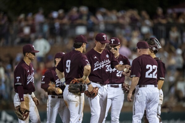 Texas A&M pitcher Justin Lamkin (33) hands the ball over to coach Jim Schlossnagle during the team's NCAA college baseball game against Arkansas on Friday, May 17, 2024, in College Station, Texas. (Meredith Seaver/College Station Eagle via AP)