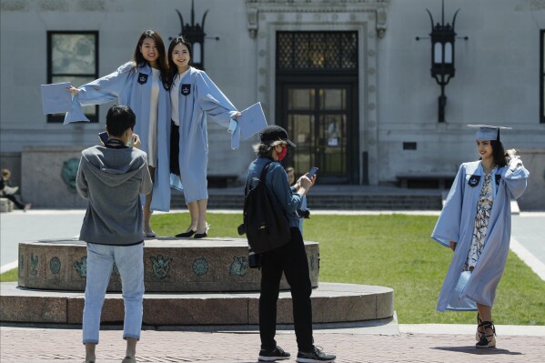 File - Columbia University class of 2020 graduates pose for photographs on Commencement Day on Wednesday, May 20, 2020, in New York. After three years, the pandemic-era freeze on student loan payments will end in late August. It might seem tempting to just keep not making payments, but the consequences can be severe, including a hit to your credit score and exclusion from future aid and benefits. (AP Photo/Frank Franklin II, File)