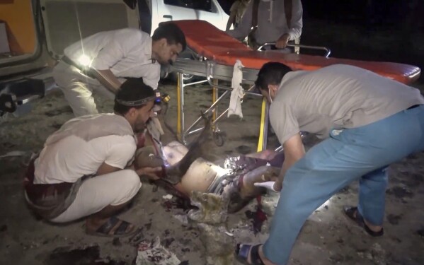 This photo taken from video released by Al Masirah TV channel shows medics carrying a severely wounded person onto a stretcher after U.S. airstrikes targeted the Ras Isa oil port held by Yemen's Houthi rebels in Hodeida, Yemen, Friday, April 18, 2025.( Al Masirah TV via AP)