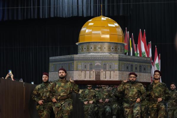 Hezbollah fighters hold a replica of the Dome of the Rock Mosque as march during a rally to mark Jerusalem day or Al-Quds day, in a southern suburb of Beirut, Lebanon, Friday, April 29, 2022. The leader of Lebanon's militant Hezbollah group warned Friday that if Israel continues to target Iran's presence in the region, Tehran could eventually retaliate by striking deep inside Israel. (AP Photo/Hassan Ammar)