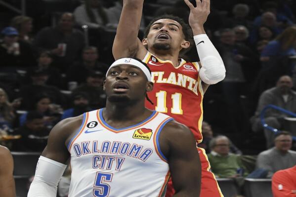 Atlanta Hawks guard Trae Young (11) shoots the ball over Oklahoma City Thunder forward Luguentz Dort (5) in the first half of an NBA basketball game, Wednesday, Jan. 25, 2023, in Oklahoma City. (AP Photo/Kyle Phillips)