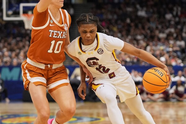 South Carolina guard MiLaysia Fulwiley (12) drives against Texas guard Shay Holle (10) during the first half of a national semifinal Final Four game during the women's NCAA college basketball tournament, Friday, April 4, 2025, in Tampa, Fla. (AP Photo/John Raoux)