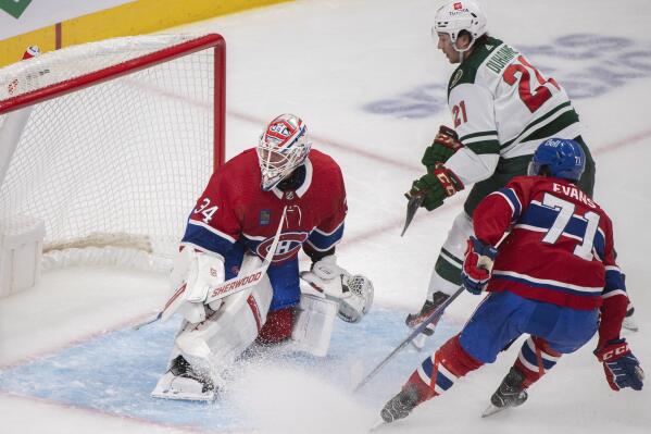 Minnesota Wild's Brandon Duhaime (21) scores on Montreal Canadiens goaltender Jake Allen as Canadiens' Jake Evans defends during the second period of an NHL hockey game, Tuesday, Oct. 25, 2022 in Montreal. (Graham Hughes/The Canadian Press via AP)