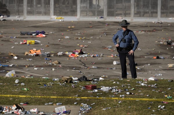 FILE - A law enforcement officer looks around the scene following a shooting at the Kansas City Chiefs NFL football Super Bowl celebration in Kansas City, Mo., Feb. 14, 2024. Kansas City, Missouri is preparing for its annual St. Patrick's Day parade on Sunday, March 17, 2024. It will be the first big mass gathering in Kansas City since Feb. 14, when gunfire erupted as about 1 million people attended a rally celebrating the Chiefs' Super Bowl win. Organizers say extra police will be on hand Sunday, along with many other precautions. (AP Photo/Charlie Riedel, file)