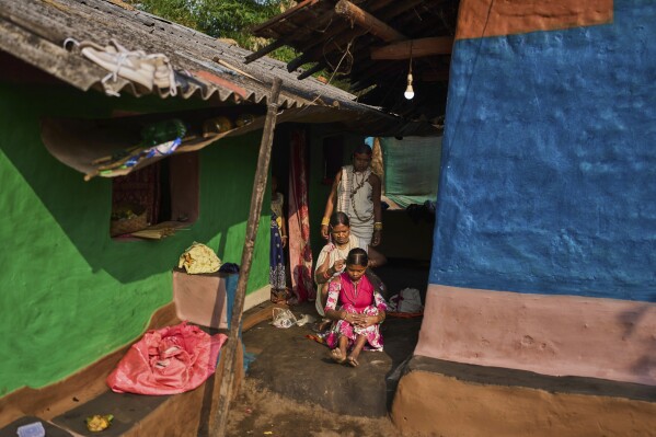 A woman, from the Durua Indigenous community, combs her daughter's hair as she dresses to take part in the Chaitra Parab festival, a monthlong harvest celebration, in Hatipakna village, Koraput district, in India's eastern state of Odisha, Thursday, April 17, 2025. (AP Photo/Rafiq Maqbool)