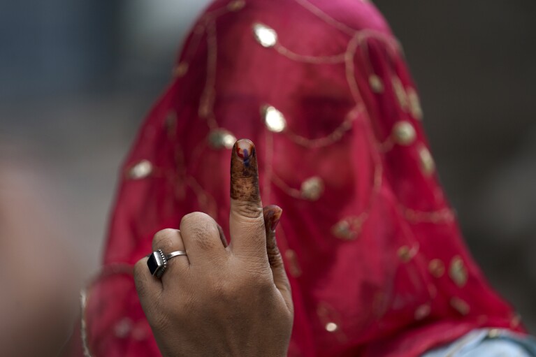 파일-한 여성이 2023년 11월 30일 목요일 인도 하이데라바드에서 열린 텔랑가나 주 의회 선거에 투표한 후 검지 손가락에 지워지지 않는 잉크 자국을 보여주고 있다. 4월 19일부터 6월 1일까지 세계 인구의 10%가 넘는 약 9억 7천만 명의 인도인이 총선에 투표할 예정이다. 이 거대한 선거 운동은 세계 최대 규모이며, 6월 4일 결과가 발표되기까지 44일이 걸린다. (AP 통신 사진/Mahesh Kumar A., 파일)