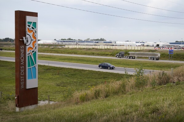 Traffic on Interstate 35 passes a Microsoft data center, Tuesday, Sept. 5, 2023, in West Des Moines, Iowa. Microsoft has been amassing a cluster of data centers to power its cloud computing services for more than a decade. Its fourth and fifth data centers in the city are due to open later this year. (AP Photo/Charlie Neibergall)