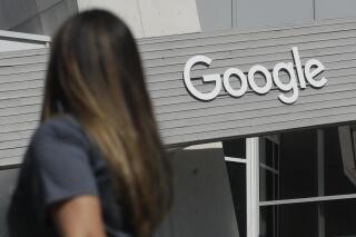 FILE - In this Sept. 24, 2019, file photo a woman walks below a Google sign on the campus in Mountain View, Calif. Alphabet reports earnings on Tuesday, April 25, 2023. (AP Photo/Jeff Chiu, File)