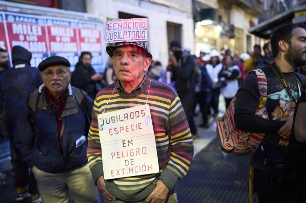 Hercot Larsen, de 74 años, lleva un cartel con la frase 